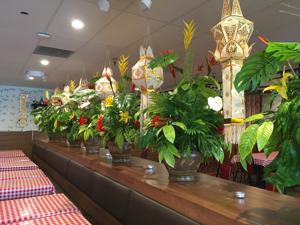 The upstairs dining room is divided by a low wall and plants